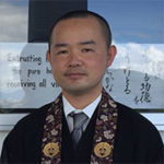 Rev. Shingo Furusawa in front of Hawaii Betsuin reader board