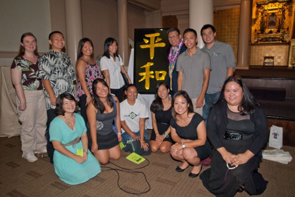 Young people from the Federation of Jr. Young Buddhist Associations with the golden Kanji peace sign and Hawaii Kyodan president Mr. Alton Miyamoto