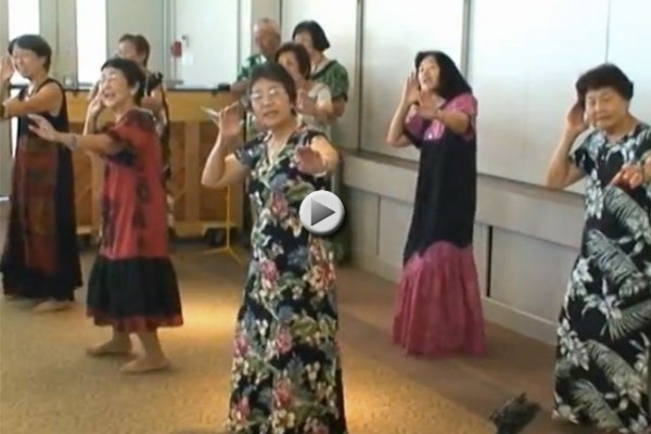 women in dresses dancing hula