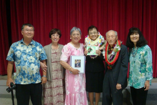 four event organizers stand with Mr. and Mrs. Saito