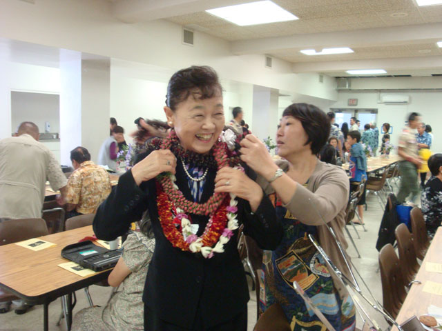 Mrs. Saito gets assistance with her many leis!