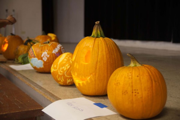 carved pumkins lined up on the stage in the social hall