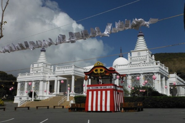 view of yagura with temple in the background and flags blowing in the breeze -- before the crowds arrive