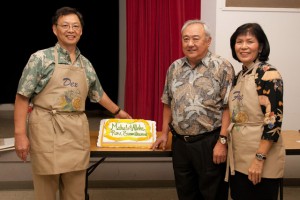 Reverend Sumikawa with Dexter and Faye Mar. A cake on the table is decorated with the words, "Mahalo & Aloha Rev. Sumikawa"