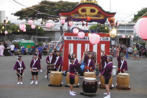 taiko drummers play in front of the yagura