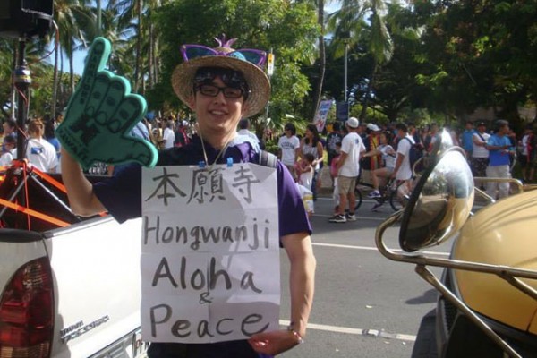 Rev. Tomioka holds a sign "Hongwanji Aloha Peace"