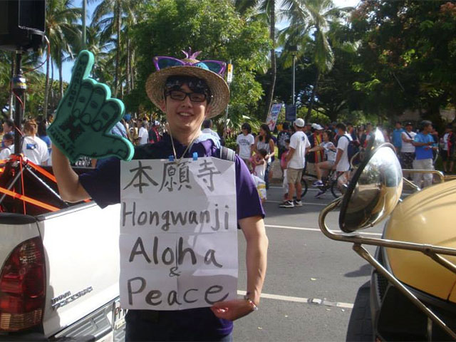 Rev. Tomioka with sign and giant shaka