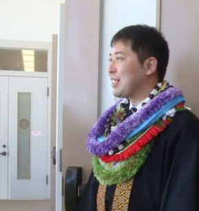 Rev. Hojo with many lei at hondo doors