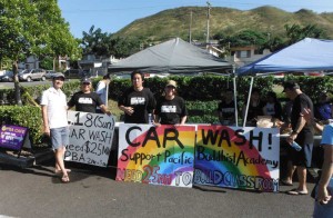 colorful car wash sign held by ministers and youth with PBA cafe tents