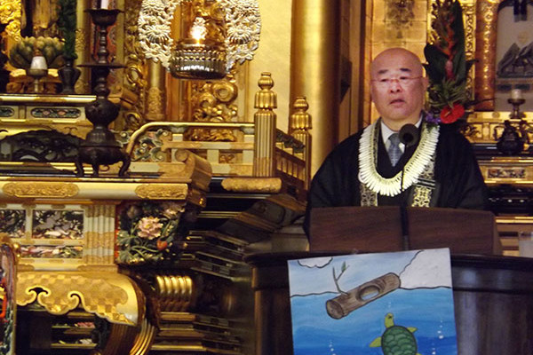 Rimban Hagio delivers a dharma talk with a picture of a turtle and a log as a visual aid