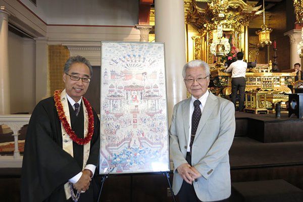 Bishop Matsumoto and Rev. Makino in the hondo next to a framed drawing of the Buddha outdoors