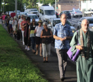 Peace Walk attendees walking in single file toward the Nagasaki Peace Bell at Honolulu Hale