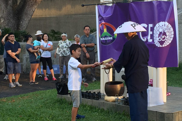 a child receives a mallet to ring the bell at the Nagasaki Peace Bell