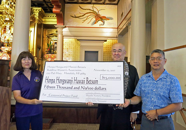 Wendie Yumori presents an oversize check for $15k to Rimban Hagio and President Jerry Tamamoto