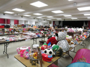 tables in the social hall loaded with Bazaar rummage sale toys and other items