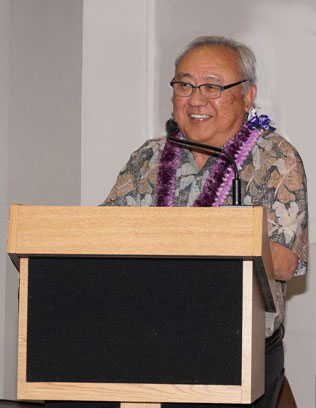 Rev. Bert Sumikawa wearing lei at the podium