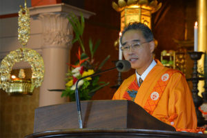 Bishop Matsumoto in orange robes at Hawaii Betsuin pulpit