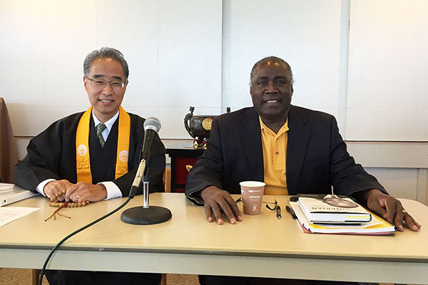Bishop Eric Matsumoto and Mr. Alphonso Braggs at table with microphone