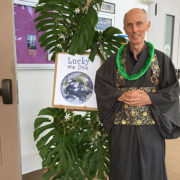 Michael Kieran (with lei) next to a bamboo "tree" decorated with greenery