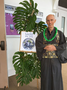 Michael Kieran (with lei) next to a bamboo "tree" decorated with greenery