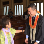 a smiling Rev. Blayne Higa greets a service-goer after the service preceding Green Fair 2019