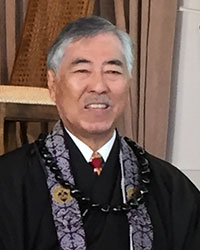 Rev. Ron Kobata in robes and kukui nut lei in Annex temple