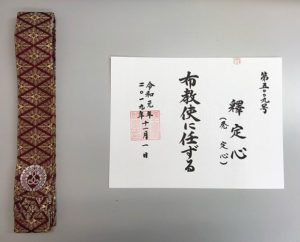 Rev. Kamuro's appointment certificate of Fukyoshi, certifying him as a specialist in delivering Dharma messages. Pictured with special monto shikisho