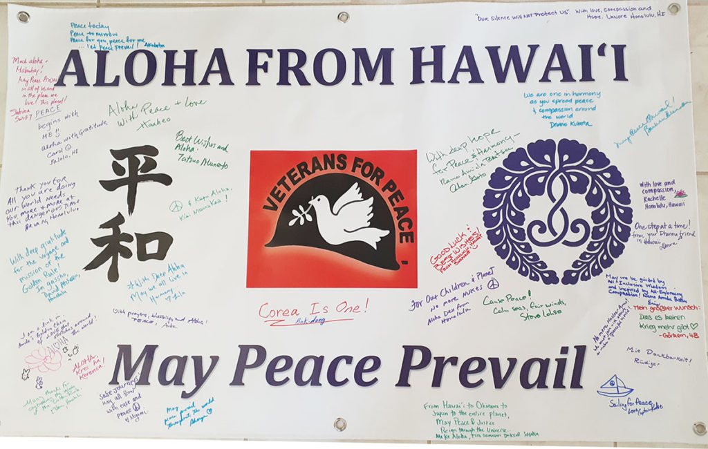 "Aloha from Hawaii: May Peace Prevail" - banner at Golden Rule event at Hawaii Betsuin showing individual messages of peace added by attendees with Sharpies