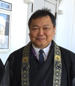 Rev. Sol Kalu in robes in front of Hawaii Betsuin hondo doors