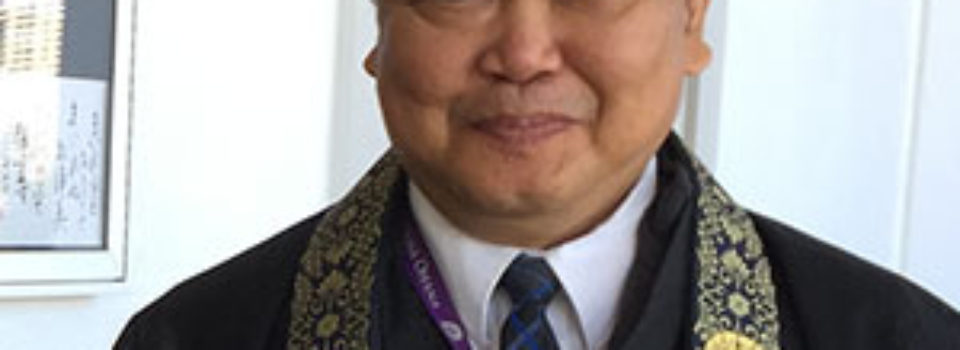 Rev. Sol Kalu in robes in front of Hawaii Betsuin hondo doors