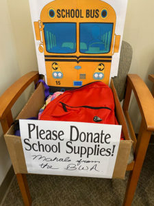 school supplies drop off station at the Hawaii Betsuin business office - box, donation sign, orange school bus backdrop