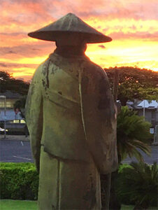 Shinran statue facing the sunset in the background