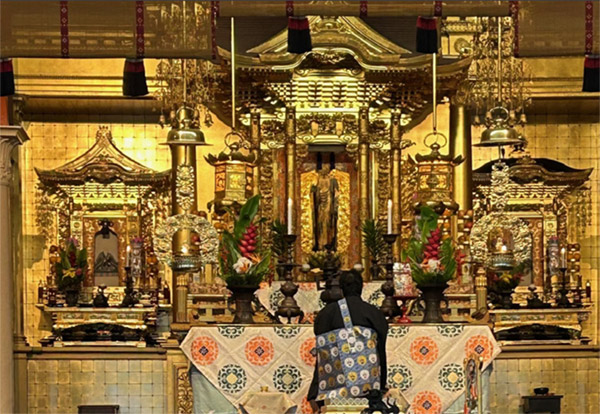 Rev. Hasebe before the restored altar in 2025